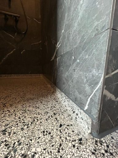 terrazzo douchevloer Grijze marmeren wand en tegelvloer met een gestreept patroon.